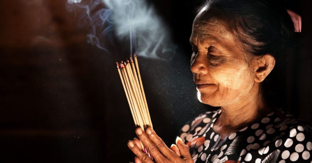 A woman praying with incense sticks