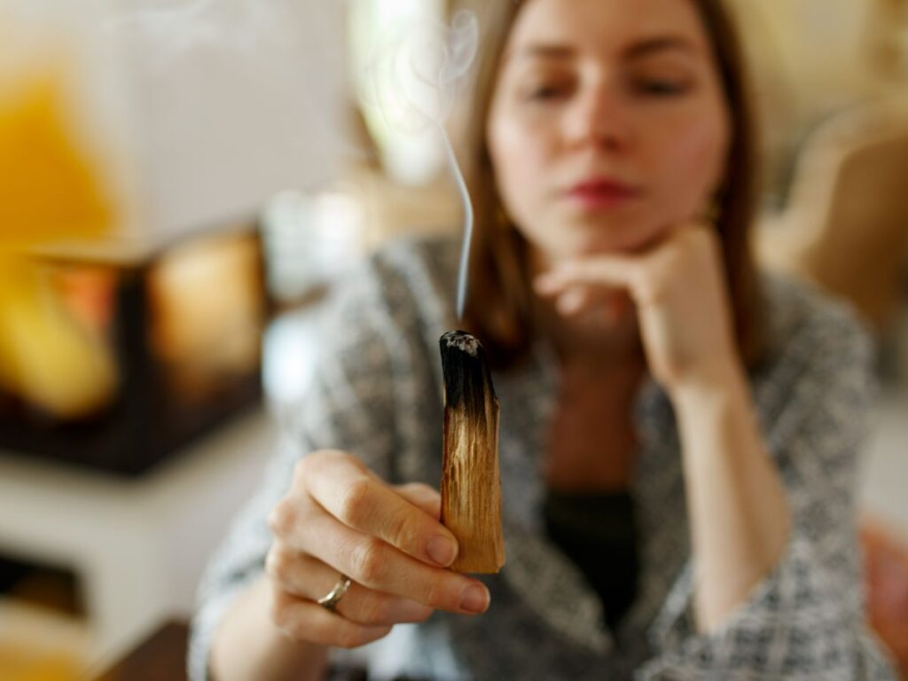 woman hands burning palo santo